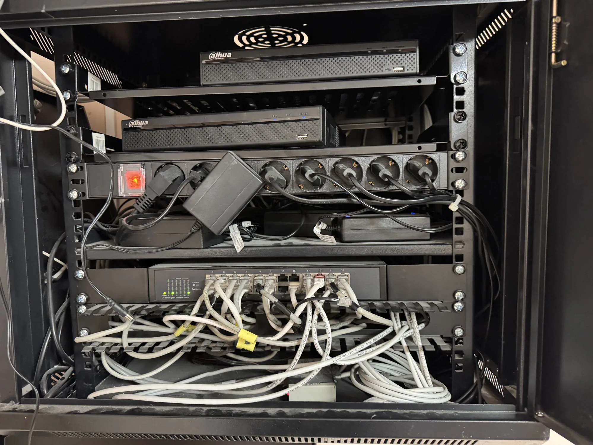 Szafa rack z poplątanym, nieuporządkowanym okablowaniem